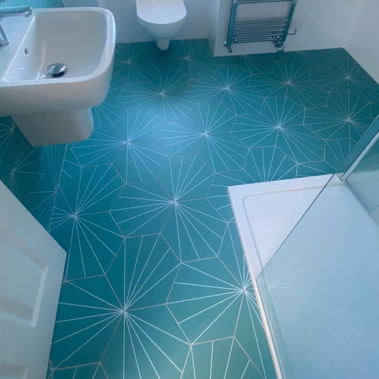 Modern bathroom with a walk-in shower, geometric feature floor tiles and contemporary white sanitaryware.