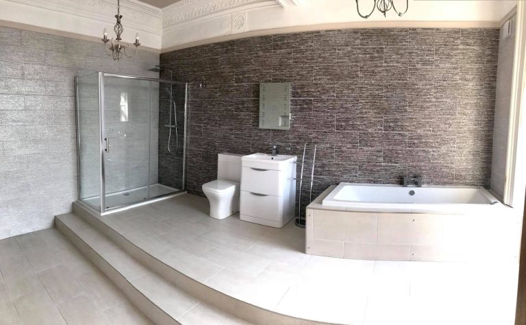 Spacious contemporary bathroom featuring a walk-in shower, modern bath, textured feature wall and elegant grey finishes.
