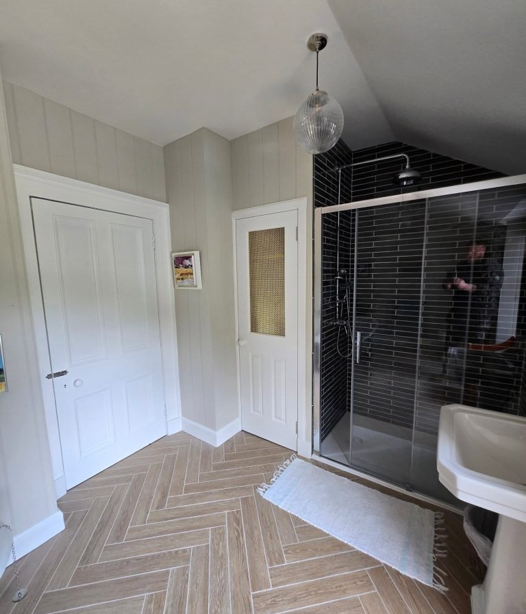 Modern bathroom featuring a walk-in shower, floating vanity and stylish wall tiles.